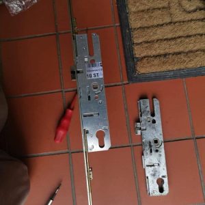 Maco multi point lock gearbox fitted to locksing strip with old faulty paid laid on red tile floor in Clitheroe