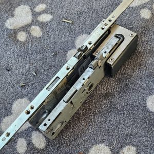 Old and new multipoint lock laid on carpet during replacement in Blackburn 